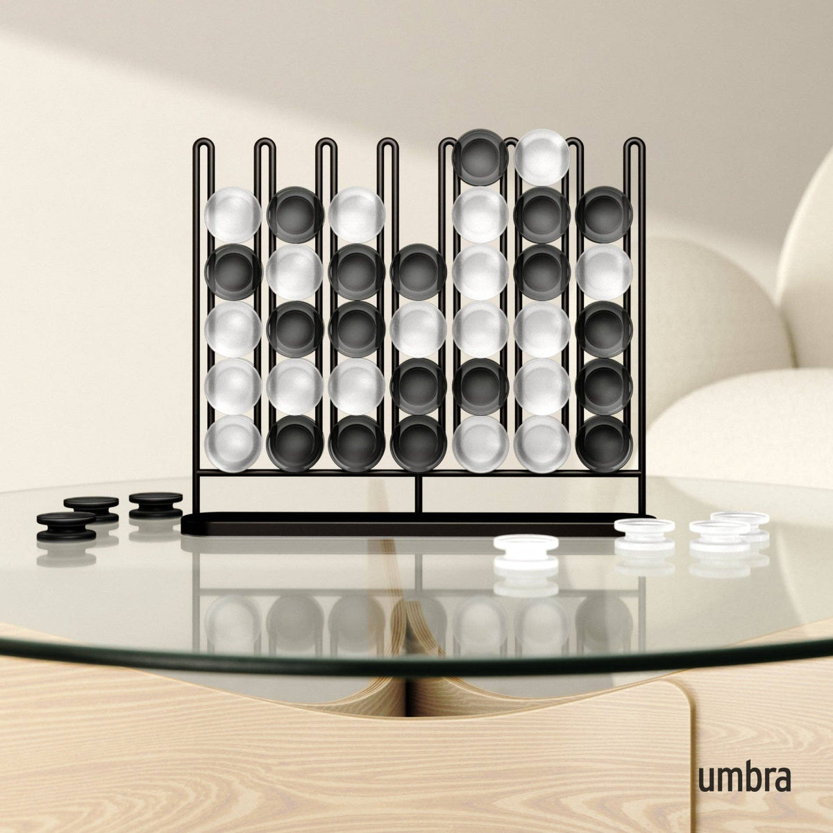 Umbra Stax Four-in-a-Row game with a black frame and frosted black and white playing pieces