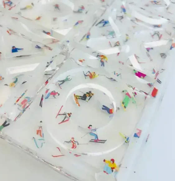 Close-up of acrylic Ski Tic-Tac-Toe board featuring colorful skier figures embedded in clear acrylic - decorative game gift for home, Long Island gift store
