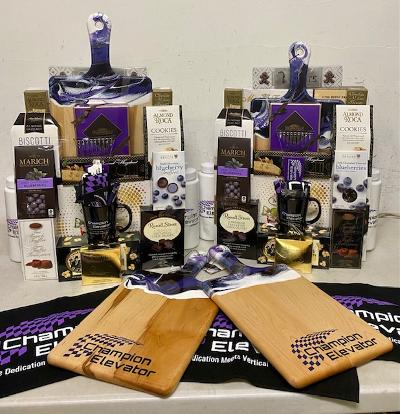 Custom logo wood charcuterie boards displayed with gourmet gift assortments in purple and black - branded corporate gift for clients, holidays and staff appreciation from a Long Island gift store serving NYC with nationwide delivery